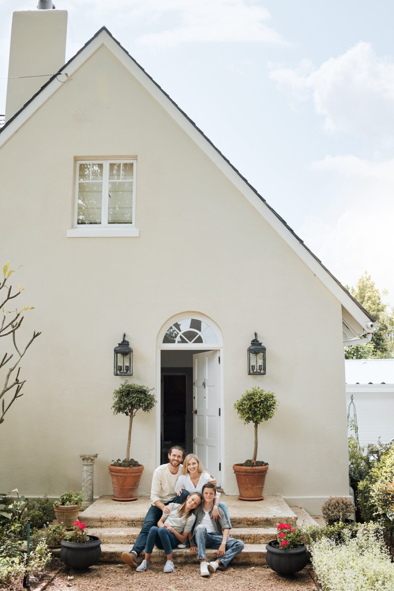 Familjen har tagit plats på trappan utanför sitt hem, som lyser upp med sin nya ljusa fasad och välkomnande gröna växter vid entrén